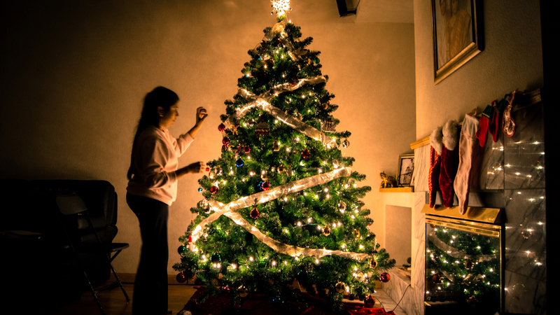 woman-decorating-ornamented-christmas-tree_800
